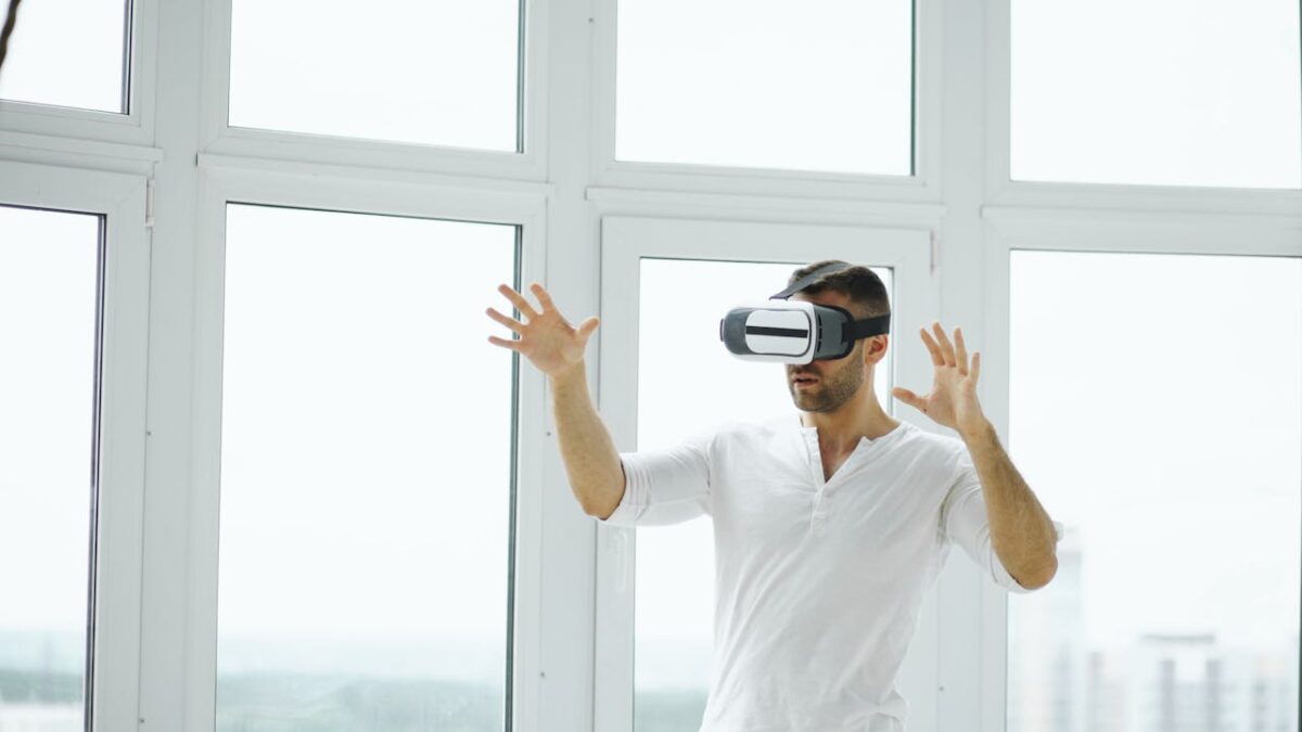 Adult man exploring virtual reality with VR headset in a bright indoor setting.